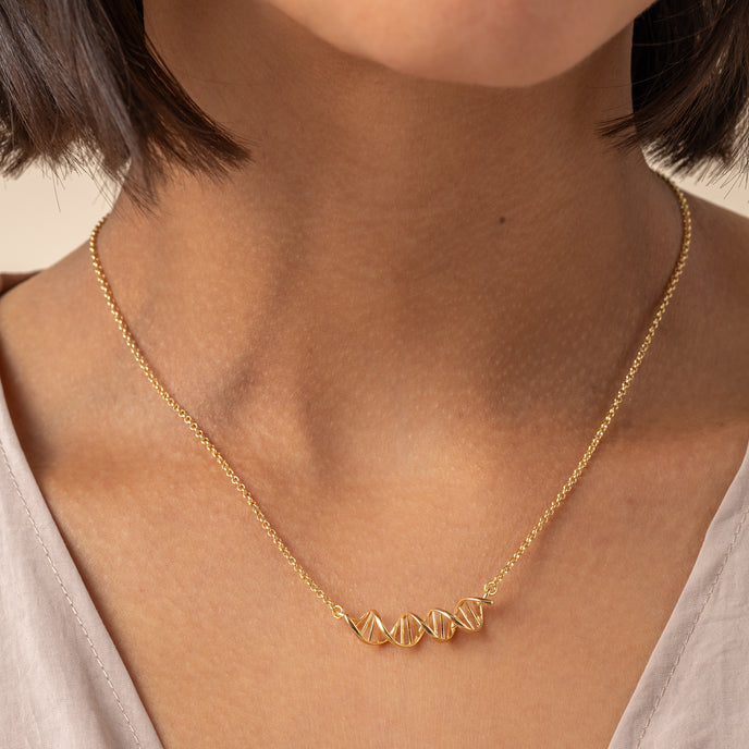 Model wearing an 18K gold vermeil DNA necklace, perfect for science lovers Model wearing an 18K gold vermeil DNA necklace, perfect for science lovers