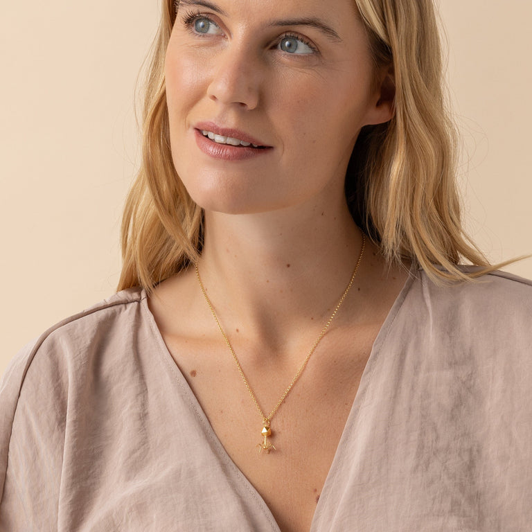 Woman wearing bacteriophage necklace in gold - geeky yet elegant science jewelry. Woman wearing bacteriophage necklace in gold - geeky yet elegant science jewelry.