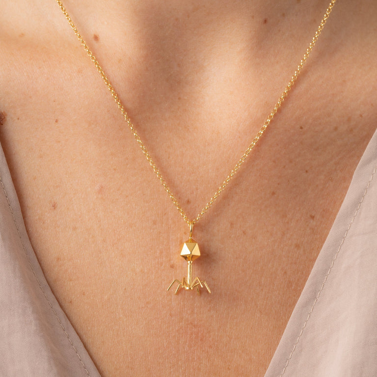 Close-up of gold vermeil bacteriophage necklace - unique microscopic virus design. Close-up of gold vermeil bacteriophage necklace - unique microscopic virus design.