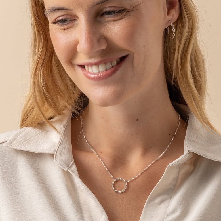 Model showcasing the sterling silver Circular DNA Necklace with a casual outfit. Model showcasing the sterling silver Circular DNA Necklace with a casual outfit.
