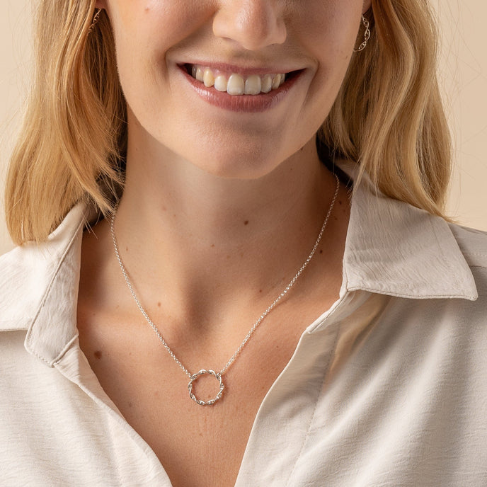 Close-up of a model wearing the Circular DNA Necklace in silver Close-up of a model wearing the Circular DNA Necklace in silver