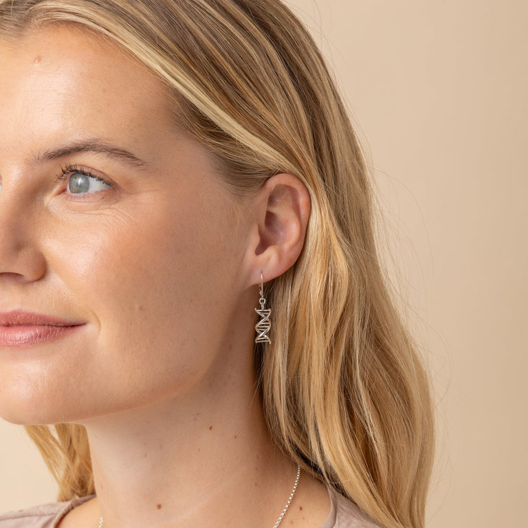 Front view of model wearing DNA-inspired sterling silver earrings, perfect for adding a scientific touch to any outfit. Front view of model wearing DNA-inspired sterling silver earrings, perfect for adding a scientific touch to any outfit.