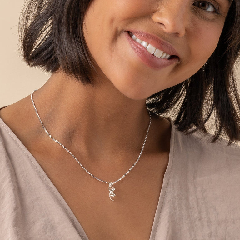 Close-up of DNA necklace in sterling silver, showcasing molecular design. Close-up of DNA necklace in sterling silver, showcasing molecular design.