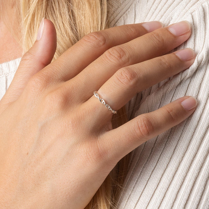 Hand wearing the silver DNA ring, highlighting its elegant, science-inspired craftsmanship. Hand wearing the silver DNA ring, highlighting its elegant, science-inspired craftsmanship.