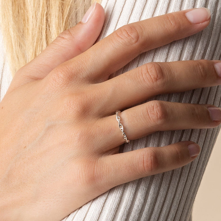 Silver DNA ring on hand, illustrating the unique and scientific essence of the jewelry piece. Silver DNA ring on hand, illustrating the unique and scientific essence of the jewelry piece.