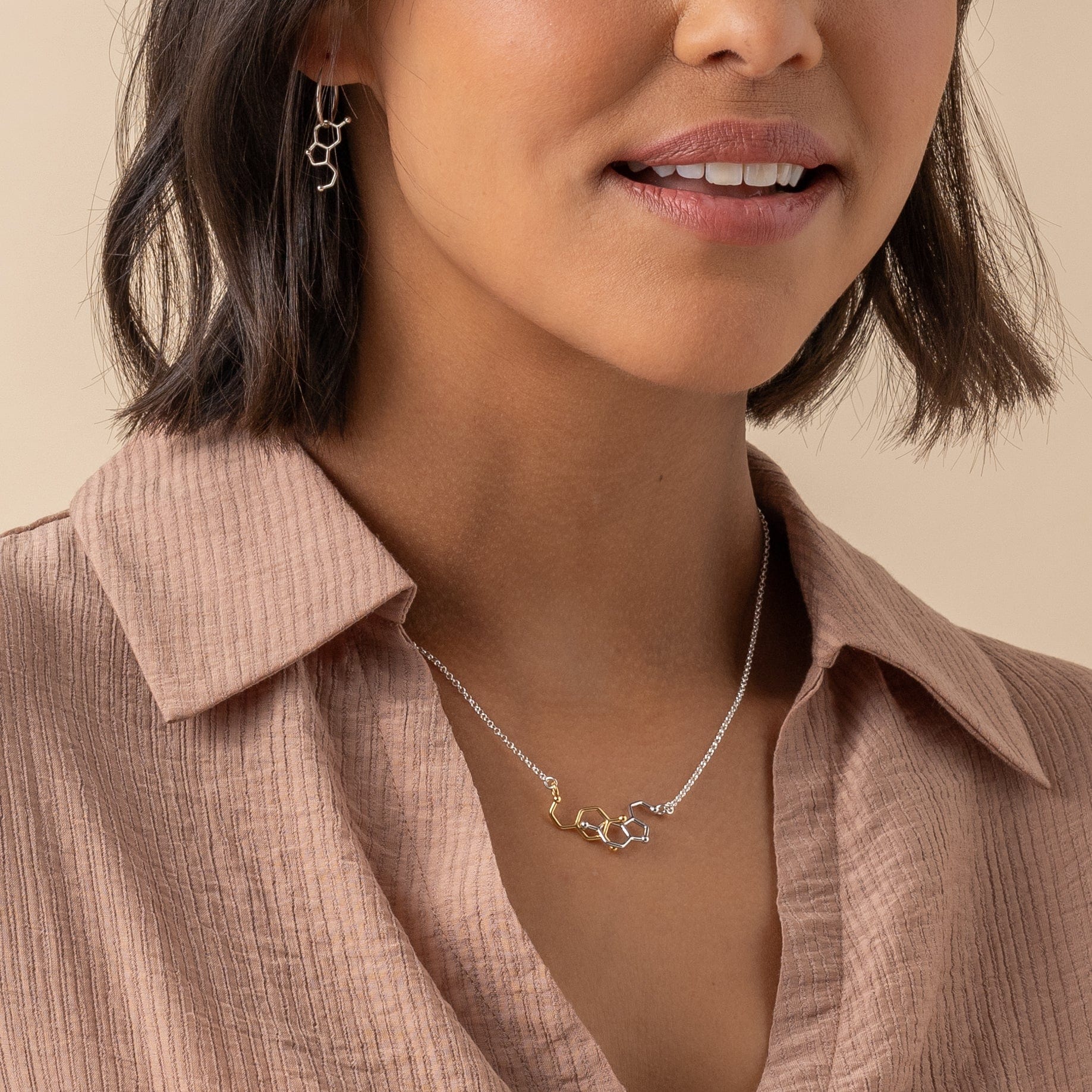 Woman wearing dopamine-serotonin necklace with a smile. Woman wearing dopamine-serotonin necklace with a smile.