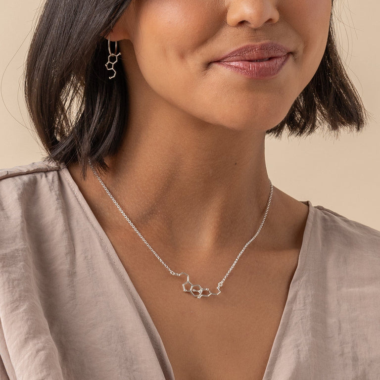 Close-up of Dopamine and Serotonin Necklace in silver, emphasizing the intricate molecular design. Close-up of Dopamine and Serotonin Necklace in silver, emphasizing the intricate molecular design.