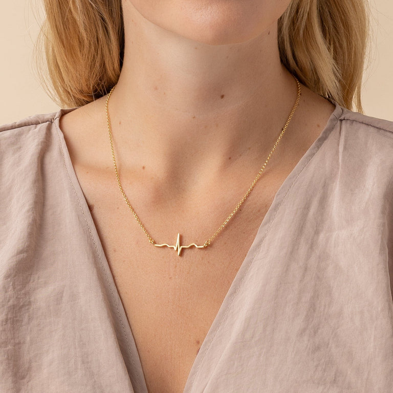 Close-up of the Vermeil Gold Heartbeat Necklace showing intricate ECG wave details. Close-up of the Vermeil Gold Heartbeat Necklace showing intricate ECG wave details.