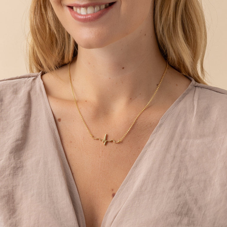 Side view of the Vermeil Gold Heartbeat Necklace highlighting its unique ECG wave design. Side view of the Vermeil Gold Heartbeat Necklace highlighting its unique ECG wave design.
