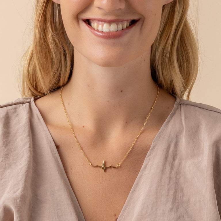 Model wearing the Vermeil Gold Heartbeat Necklace, showcasing the blend of science and elegance. Model wearing the Vermeil Gold Heartbeat Necklace, showcasing the blend of science and elegance.