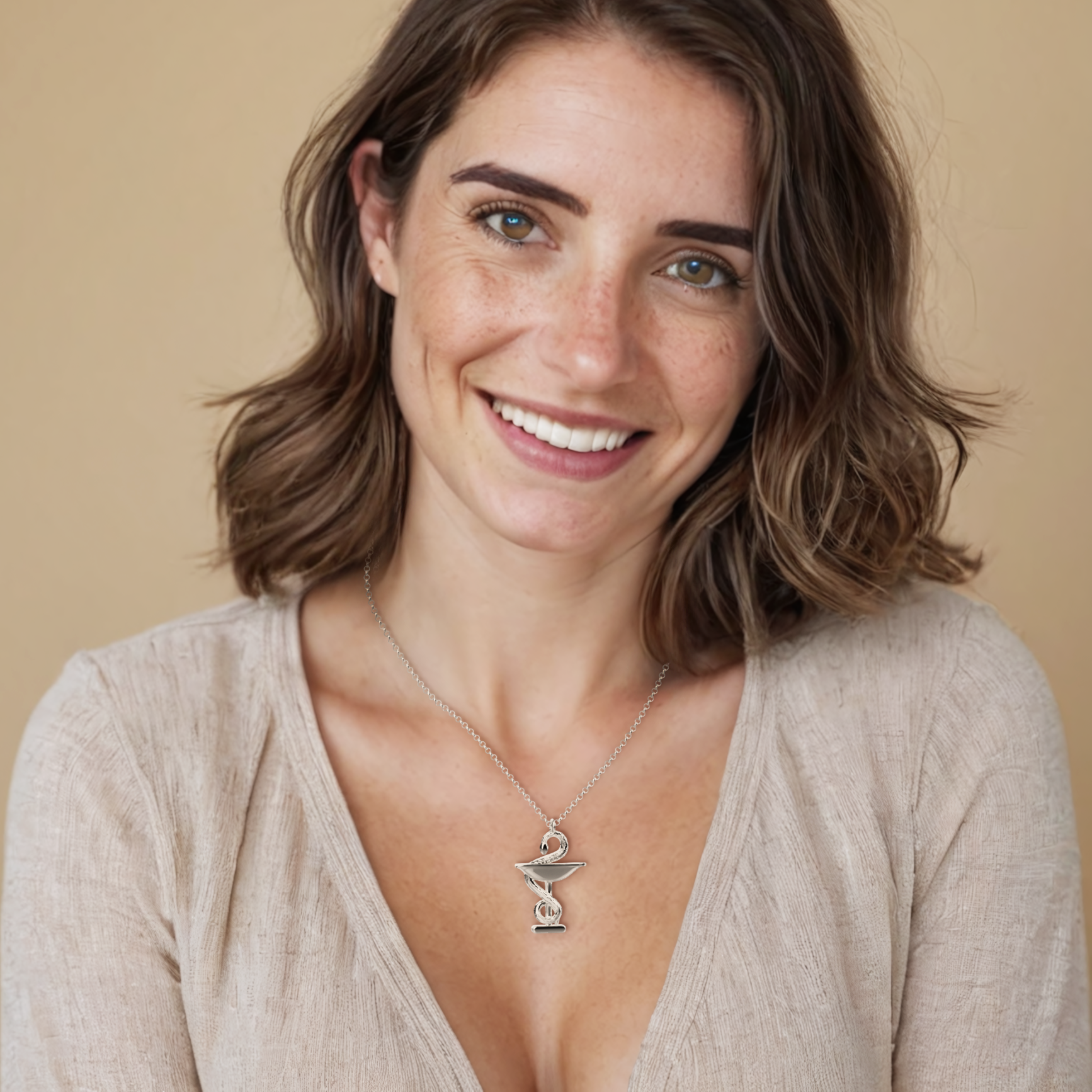 Woman wearing the Bowl of Hygieia necklace, showcasing its elegant silver design—a stylish tribute to the history of medicine and pharmacy. Woman wearing the Bowl of Hygieia necklace, showcasing its elegant silver design—a stylish tribute to the history of medicine and pharmacy.