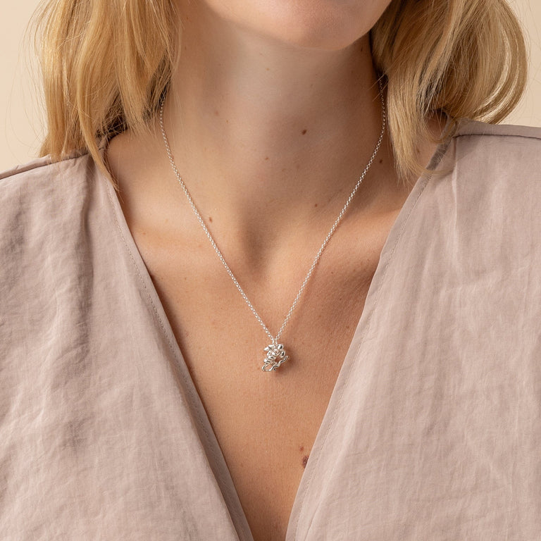 Close-up of insulin necklace on model, showcasing the detailed molecular structure. Close-up of insulin necklace on model, showcasing the detailed molecular structure.