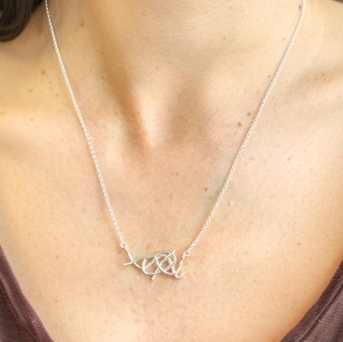 Close-up of the sterling silver nanofibers necklace resting on a woman’s collarbone, highlighting the intricate twisted design and delicate silver chain. Close-up of the sterling silver nanofibers necklace resting on a woman’s collarbone, highlighting the intricate twisted design and delicate silver chain.
