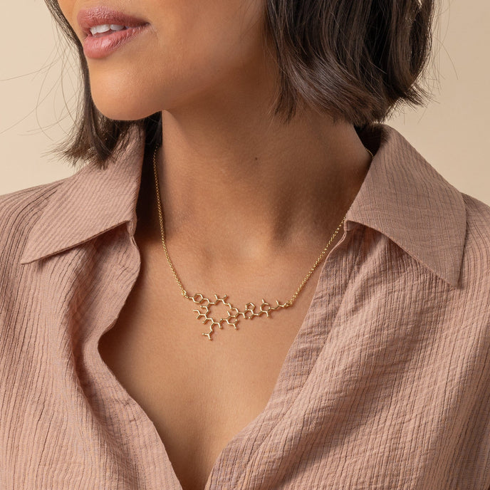Model wearing the Oxytocin Necklace, highlighting the elegant design inspired by the bonding hormone. Model wearing the Oxytocin Necklace, highlighting the elegant design inspired by the bonding hormone.
