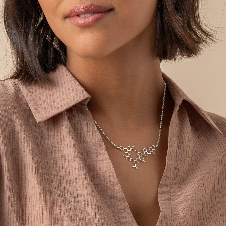 Side view of the oxytocin necklace, illustrating its minimalist and meaningful design. Side view of the oxytocin necklace, illustrating its minimalist and meaningful design.