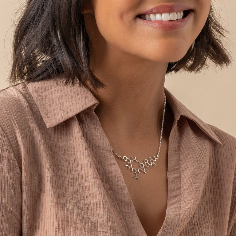 Oxytocin necklace in sterling silver, worn by the model, capturing the essence of connection and scientific elegance. Oxytocin necklace in sterling silver, worn by the model, capturing the essence of connection and scientific elegance.