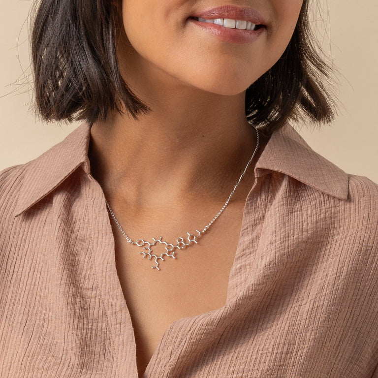 Oxytocin necklace styled on the model, celebrating the science of human bonds. Oxytocin necklace styled on the model, celebrating the science of human bonds.