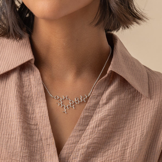 Model wearing the oxytocin necklace, highlighting the sleek and flat design perfect for everyday wear. Model wearing the oxytocin necklace, highlighting the sleek and flat design perfect for everyday wear.