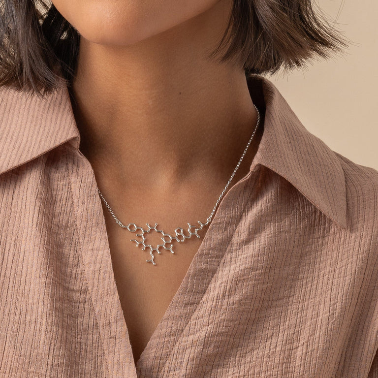 Model wearing the oxytocin necklace, highlighting the sleek and flat design perfect for everyday wear. Model wearing the oxytocin necklace, highlighting the sleek and flat design perfect for everyday wear.