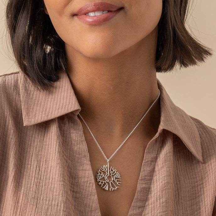 Woman wearing phylogenetic tree necklace, a silver pendant inspired by the journey of life. Woman wearing phylogenetic tree necklace, a silver pendant inspired by the journey of life.