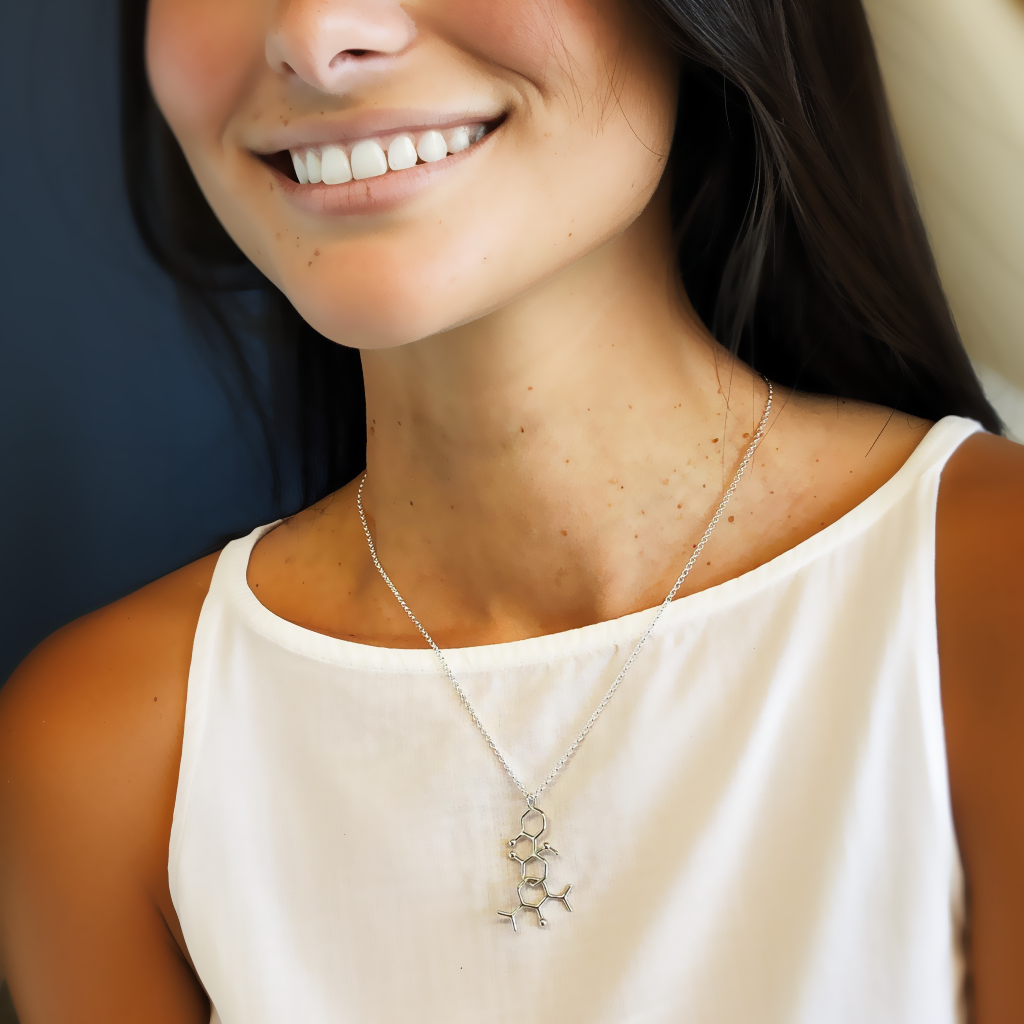 Woman wearing a ketamine propofol necklace in sterling silver, close-up of molecular design, science jewelry for stylish professionals. Woman wearing a ketamine propofol necklace in sterling silver, close-up of molecular design, science jewelry for stylish professionals.