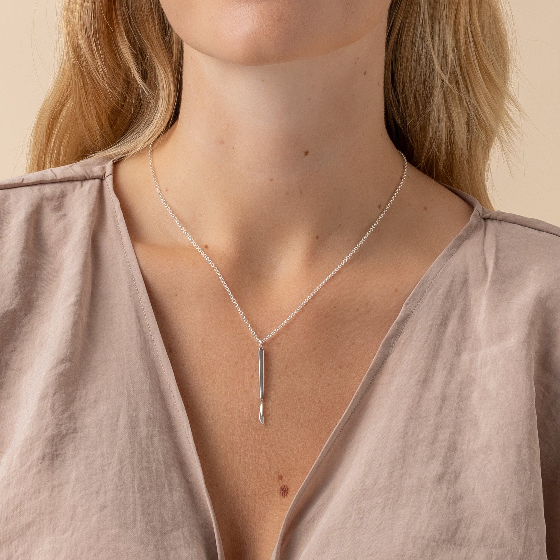 Close-up of sterling silver scalpel necklace, 3D-printed for precise craftsmanship. Close-up of sterling silver scalpel necklace, 3D-printed for precise craftsmanship.