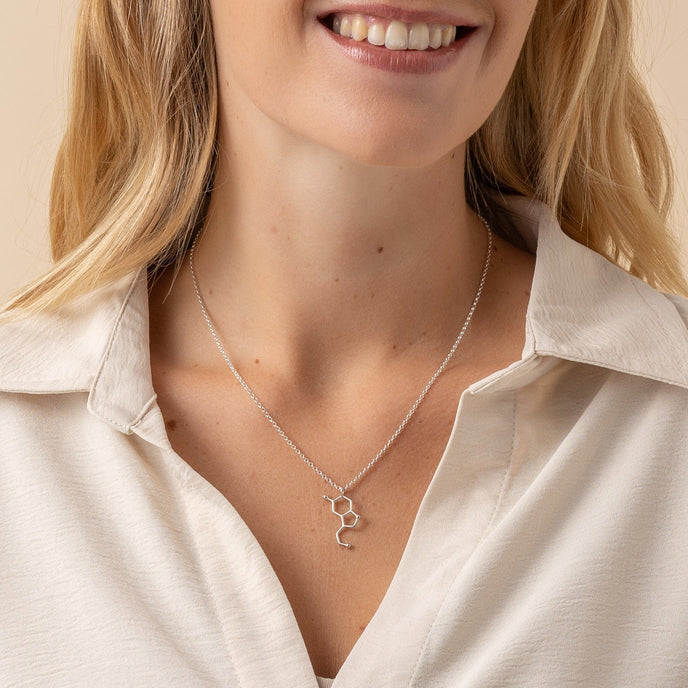 Model wearing serotonin necklace, highlighting its sleek and scientific design. Model wearing serotonin necklace, highlighting its sleek and scientific design.