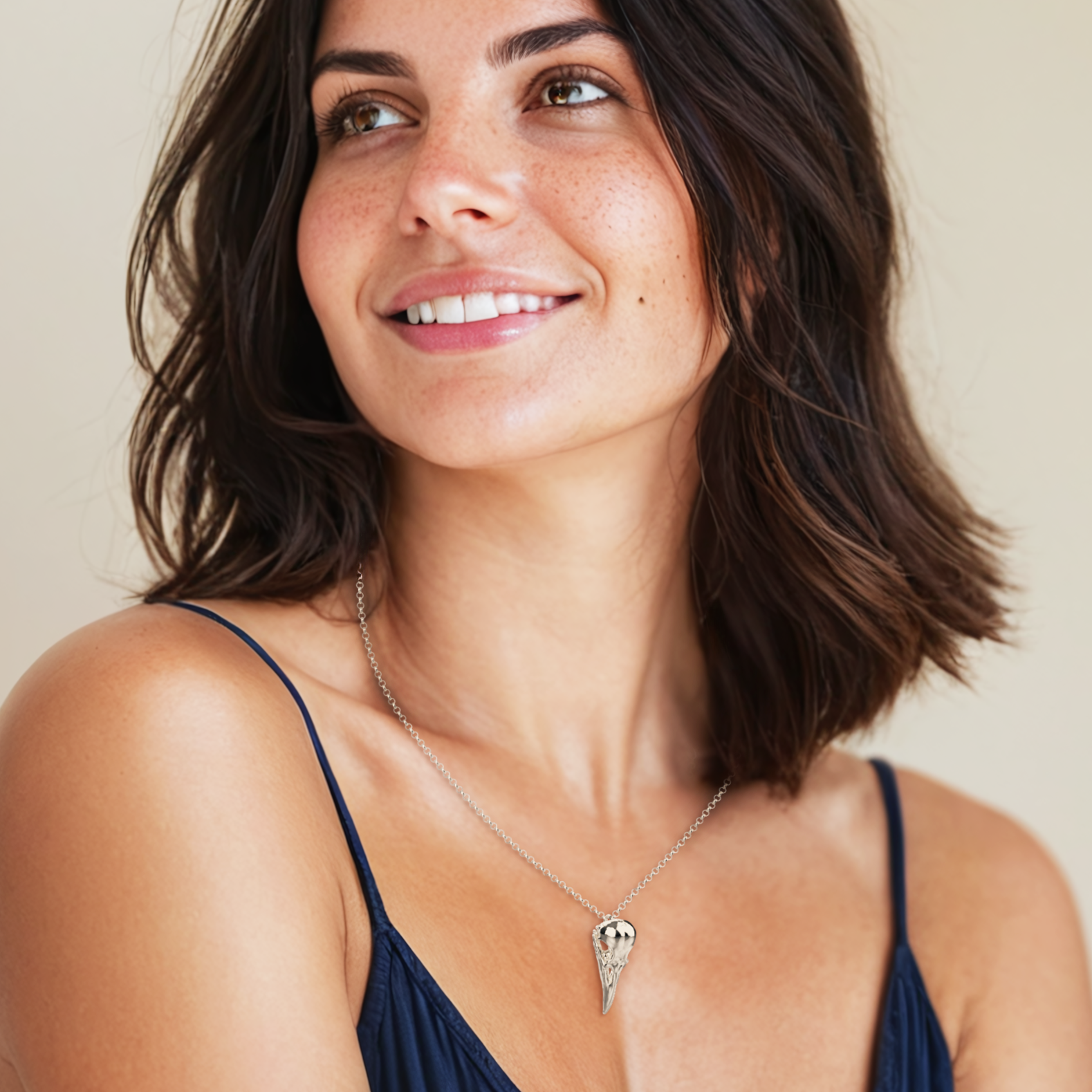 Woman wearing the Raven Skull Necklace, demonstrating the elegant yet bold look of the silver pendant. Woman wearing the Raven Skull Necklace, demonstrating the elegant yet bold look of the silver pendant.