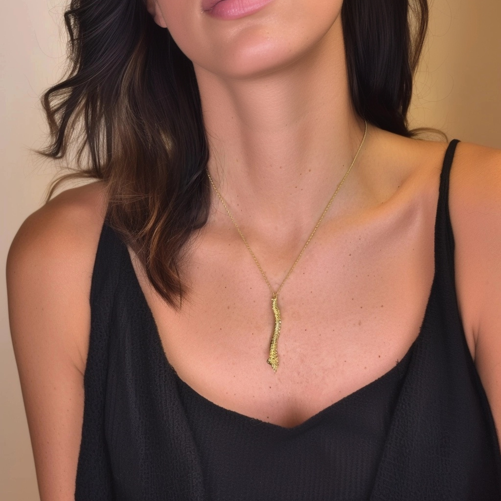 Model wearing a black top showcasing the gold vermeil spine necklace, which hangs centered along the chest. Model wearing a black top showcasing the gold vermeil spine necklace, which hangs centered along the chest.