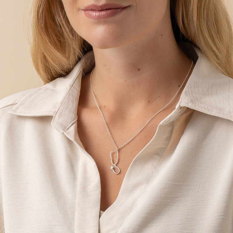 Detailed view of the Stethoscope Necklace on a model, highlighting its sophisticated appeal. Detailed view of the Stethoscope Necklace on a model, highlighting its sophisticated appeal.
