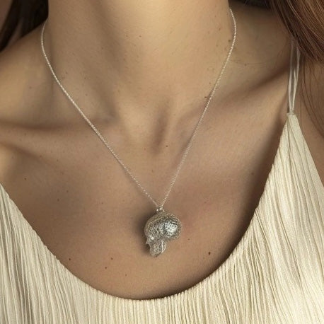 A close-up of a woman’s neck wearing the Voronoi Skull Necklace. The delicate silver chain holds the intricately designed skull pendant, which rests just above her collarbone A close-up of a woman’s neck wearing the Voronoi Skull Necklace. The delicate silver chain holds the intricately designed skull pendant, which rests just above her collarbone