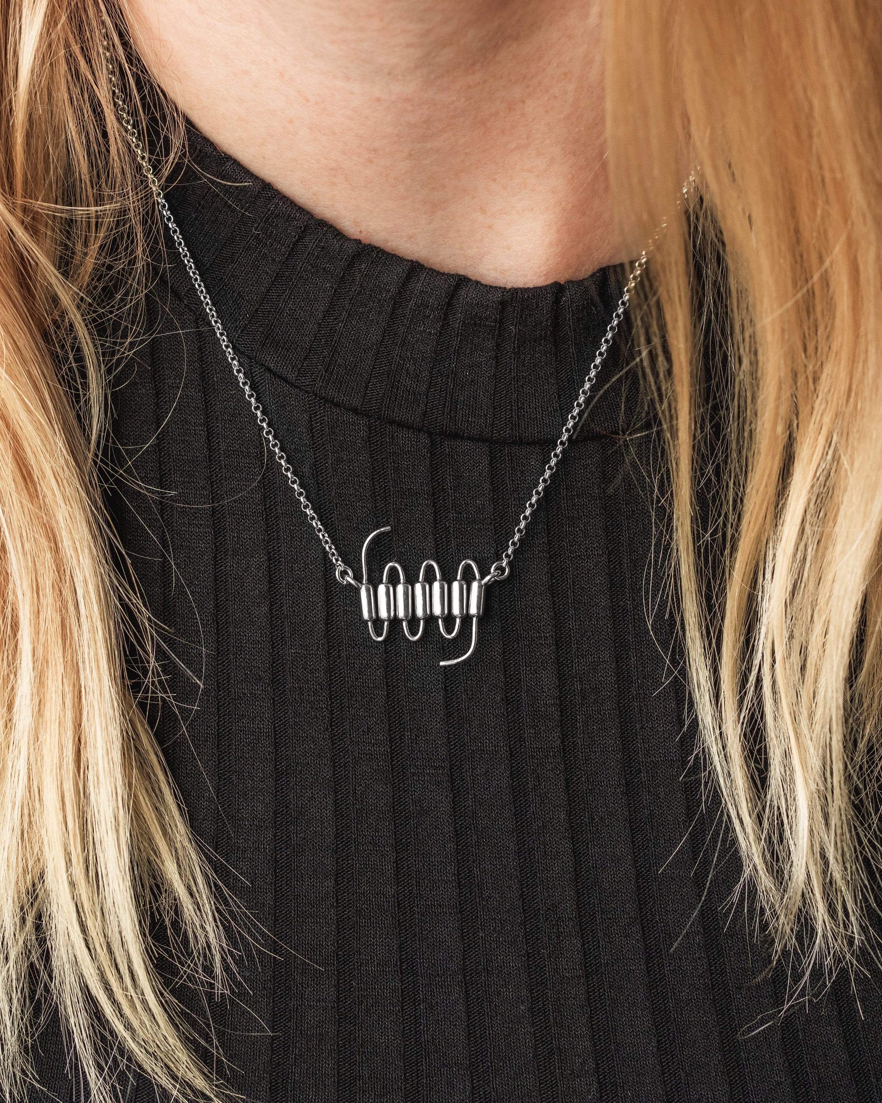Close-up view of 7TMR necklace, showcasing elegant sterling silver design inspired by cellular receptors. Close-up view of 7TMR necklace, showcasing elegant sterling silver design inspired by cellular receptors.