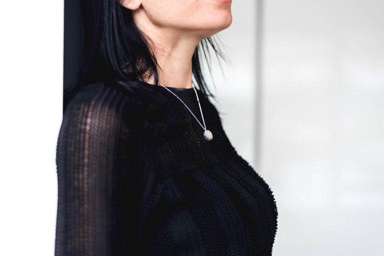 Close-up of a woman wearing the brain pendant necklace, highlighting its intricate design. Close-up of a woman wearing the brain pendant necklace, highlighting its intricate design.