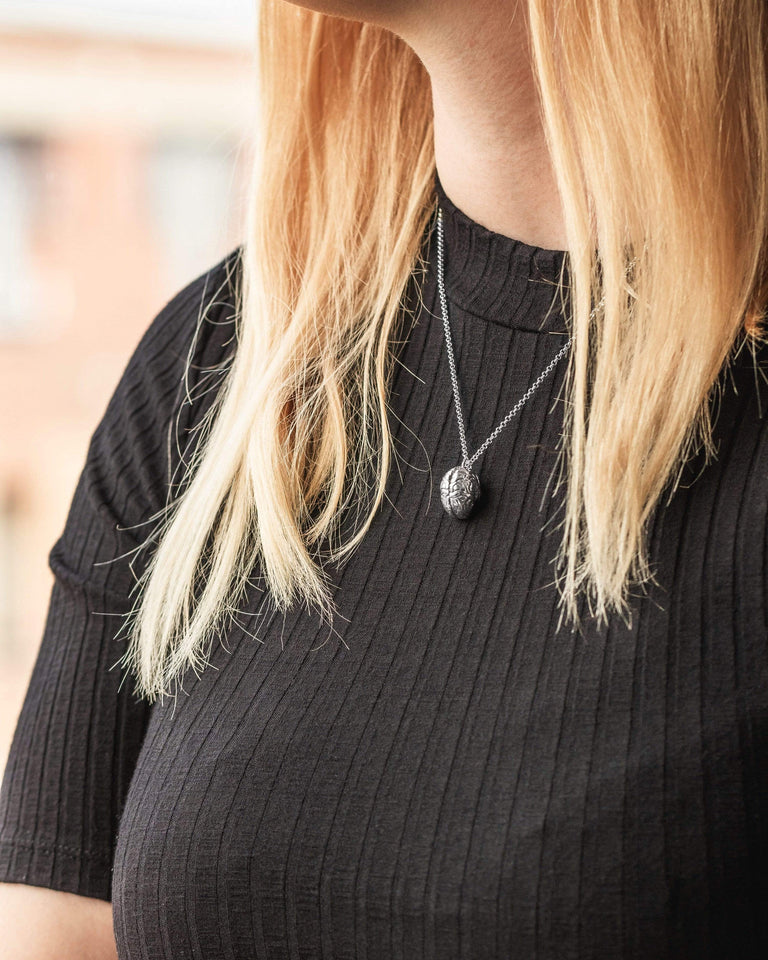 Model showcasing the brain necklace, a must-have for science enthusiasts and students. Model showcasing the brain necklace, a must-have for science enthusiasts and students.