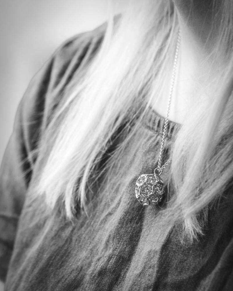 Close-up of a clathrin vesicle-inspired necklace in silver, combining science and fashion. Close-up of a clathrin vesicle-inspired necklace in silver, combining science and fashion.