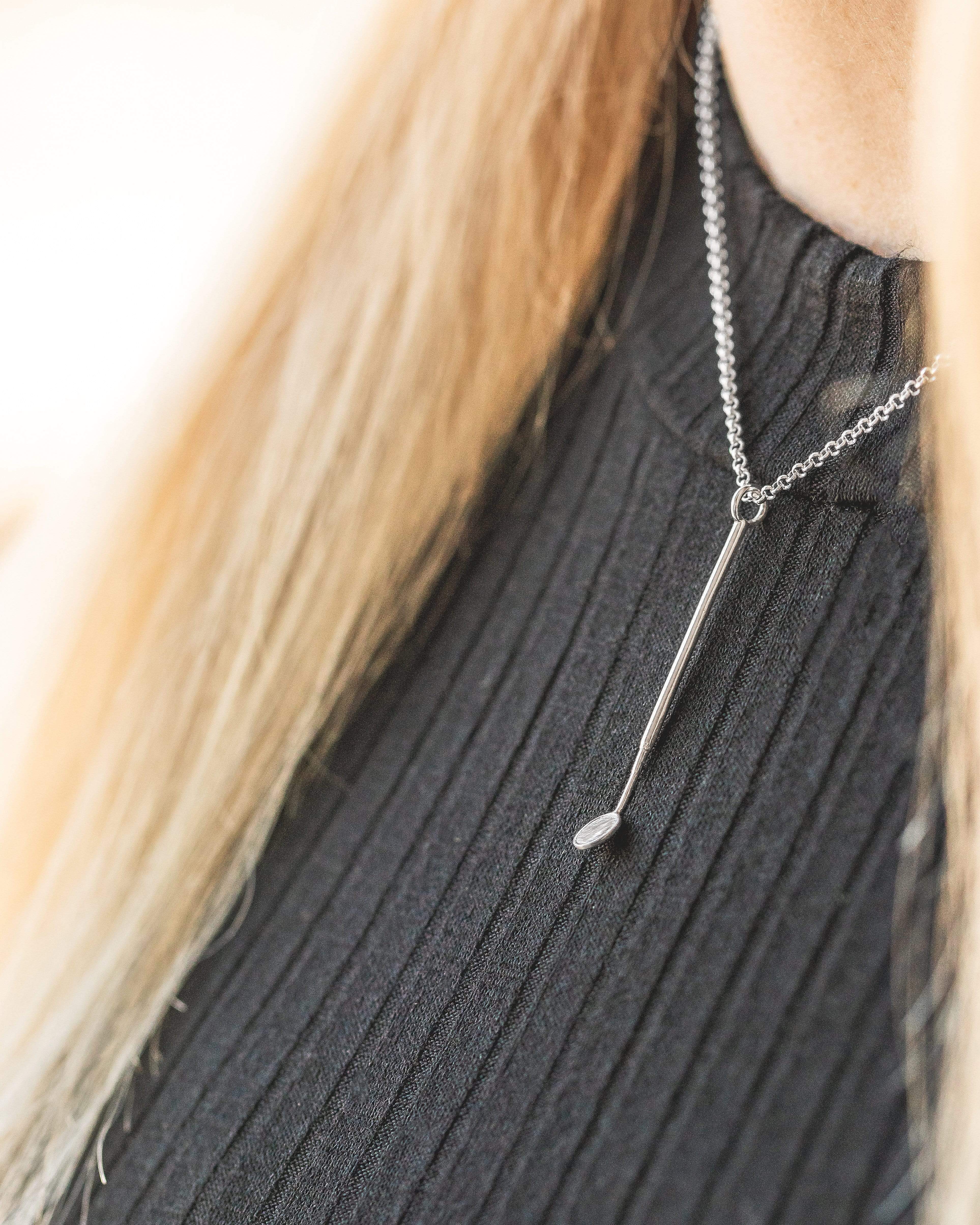 Close-up of the dental mirror necklace worn around a model’s neck, showcasing its reflective charm and unique design. Close-up of the dental mirror necklace worn around a model’s neck, showcasing its reflective charm and unique design.