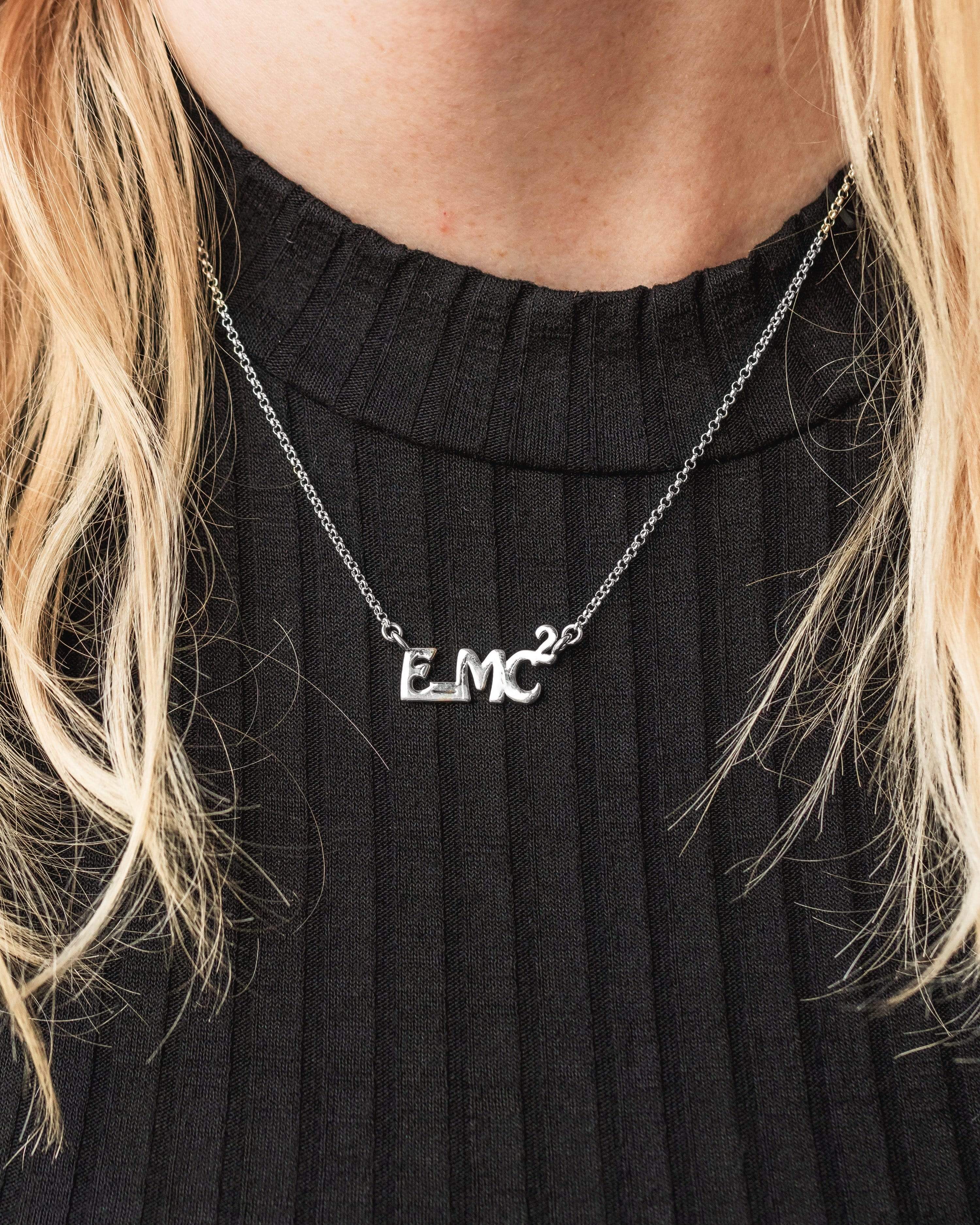 A model wearing the E=MC² necklace, showcasing its elegant scientific appeal. A model wearing the E=MC² necklace, showcasing its elegant scientific appeal.