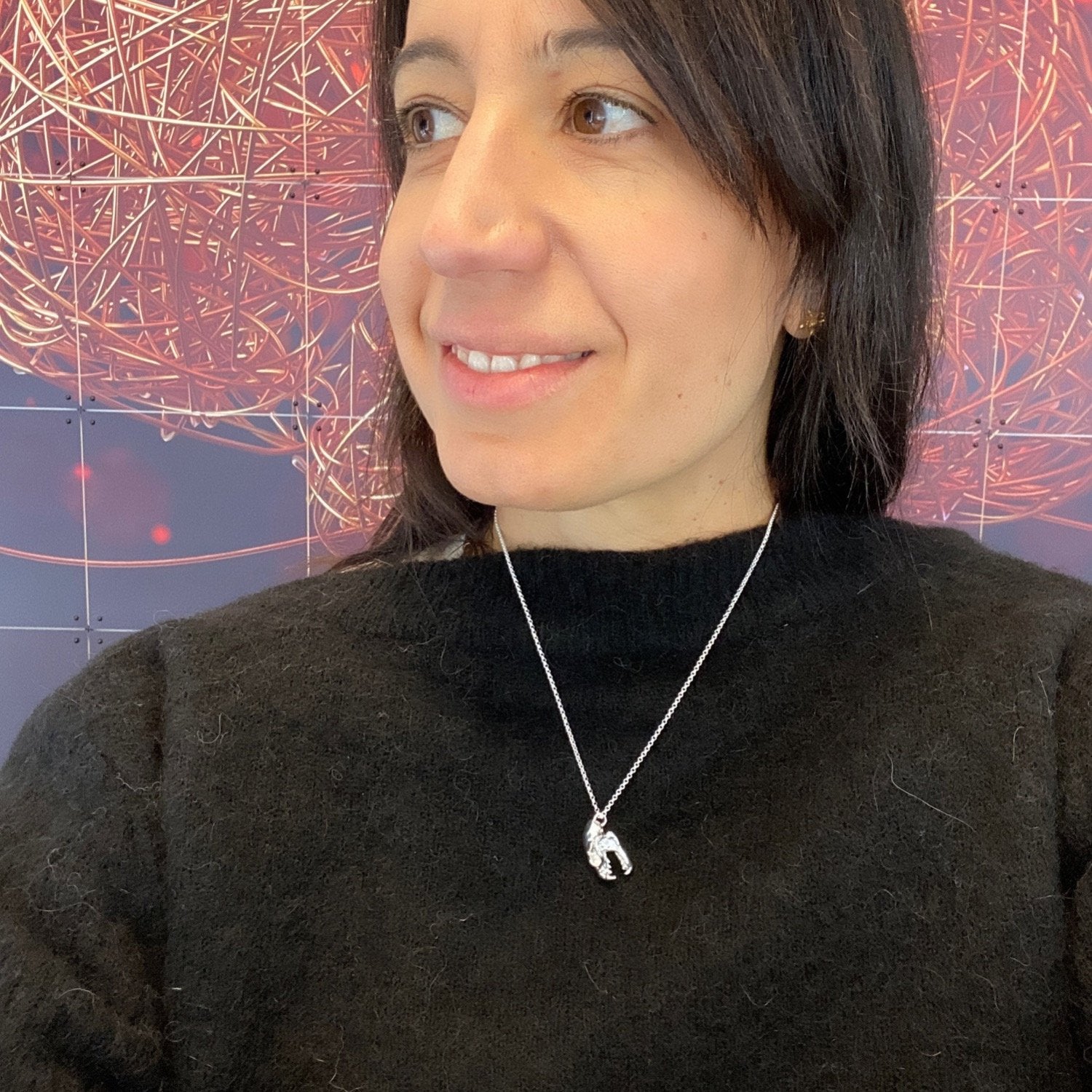 Person wearing a silver fruit bat skull necklace – unique science jewelry inspired by real fruit bat anatomy. Person wearing a silver fruit bat skull necklace – unique science jewelry inspired by real fruit bat anatomy.