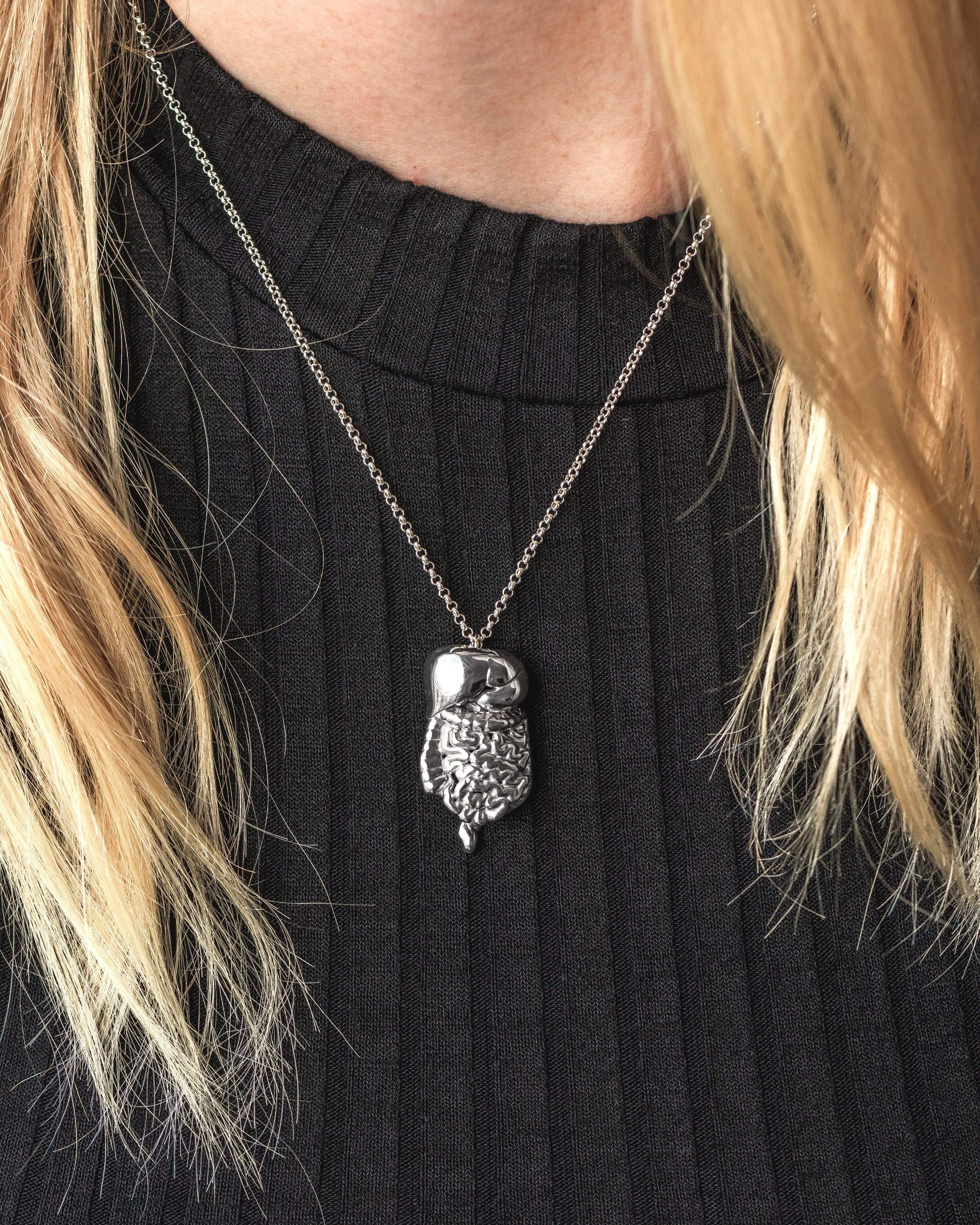 Model wearing the silver gastrointestinal tract necklace, styled with casual attire. Model wearing the silver gastrointestinal tract necklace, styled with casual attire.