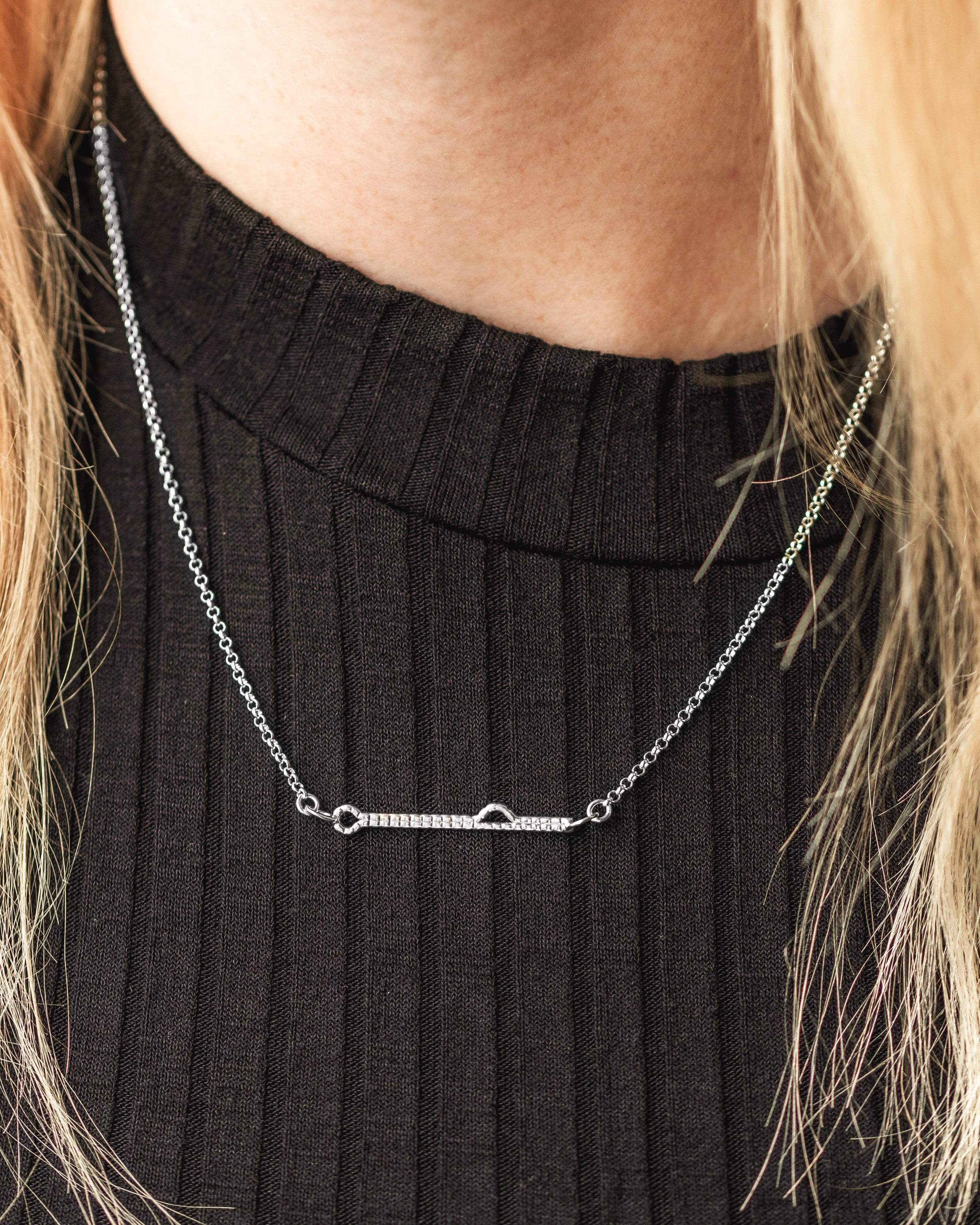 Close-up of a model wearing the sterling silver shRNA necklace, showcasing its elegant scientific design. Close-up of a model wearing the sterling silver shRNA necklace, showcasing its elegant scientific design.