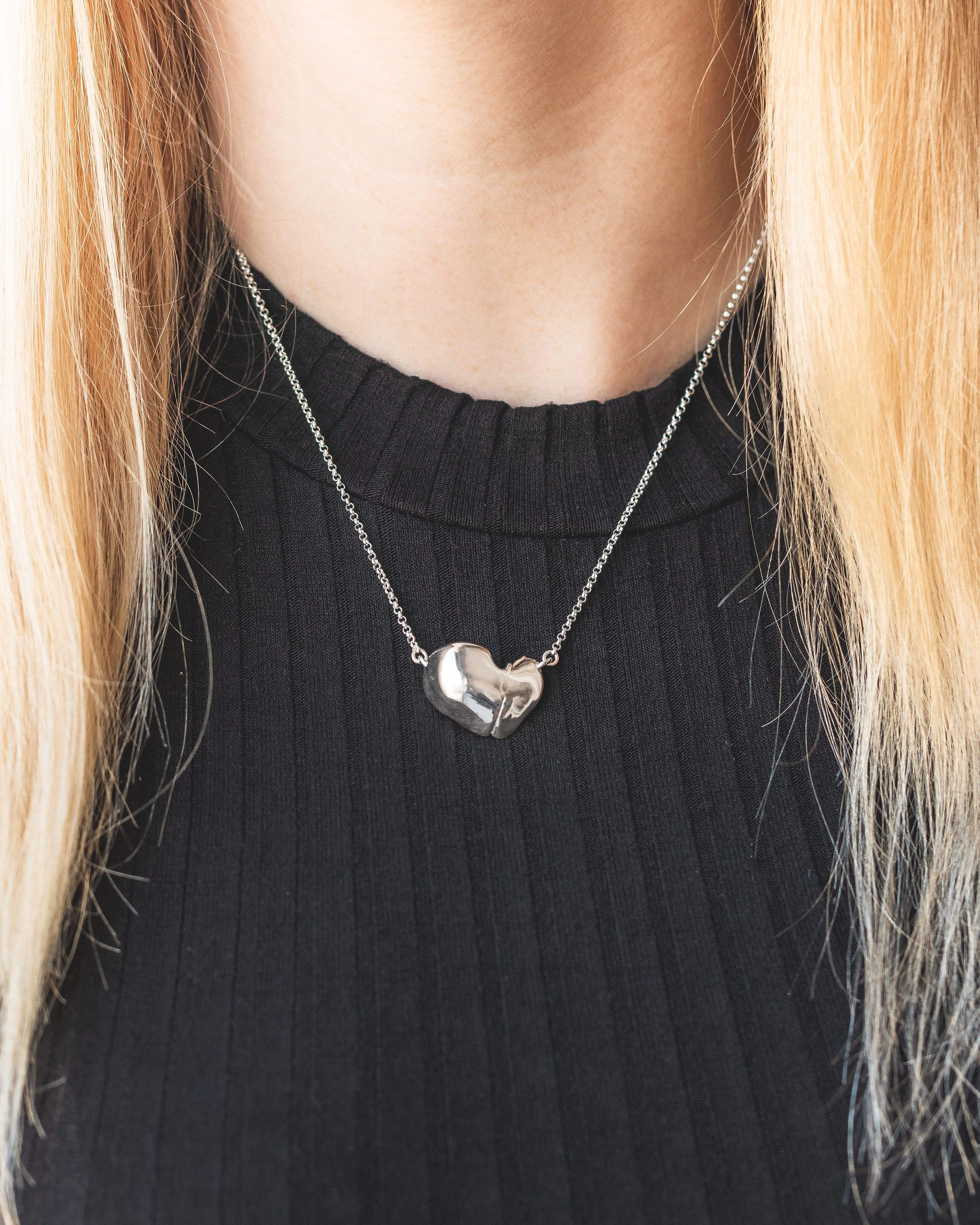 Close-up of a liver-shaped necklace in silver, perfect for hepatologists, liver donors, and science enthusiasts. Close-up of a liver-shaped necklace in silver, perfect for hepatologists, liver donors, and science enthusiasts.