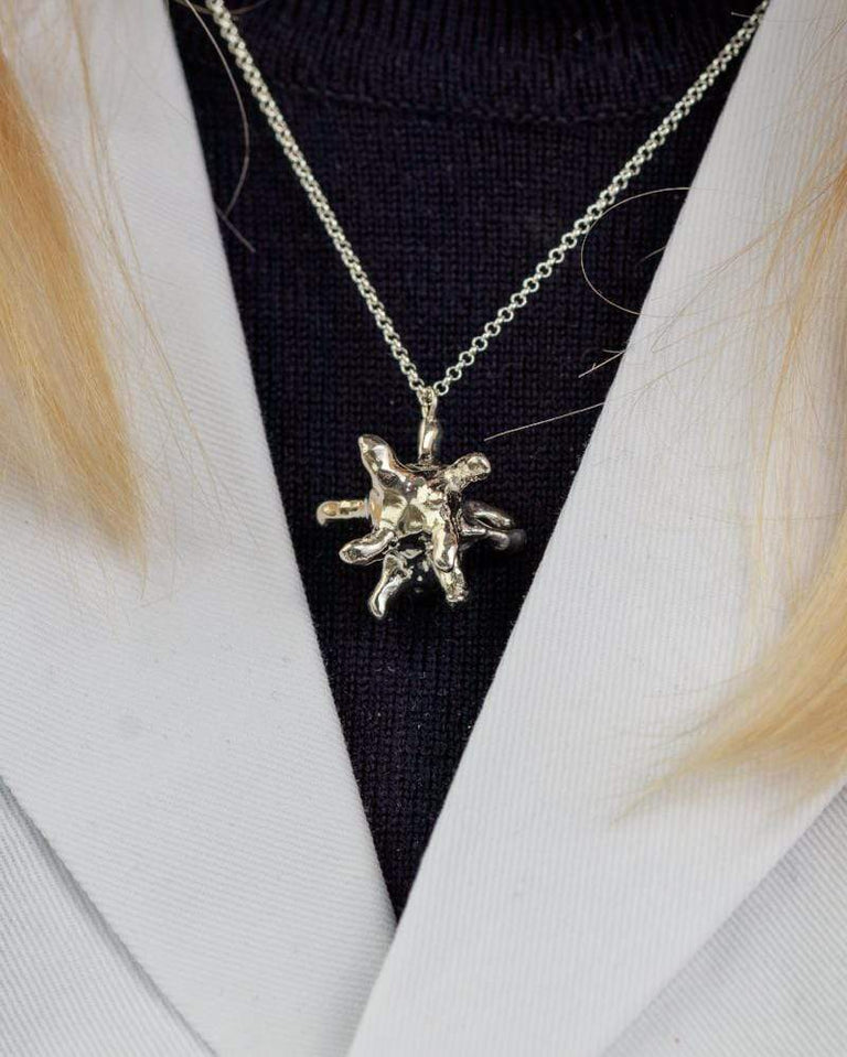 Close-up of a macrophage necklace in sterling silver, featuring a unique design inspired by immune cells, perfect for science enthusiasts. Close-up of a macrophage necklace in sterling silver, featuring a unique design inspired by immune cells, perfect for science enthusiasts.