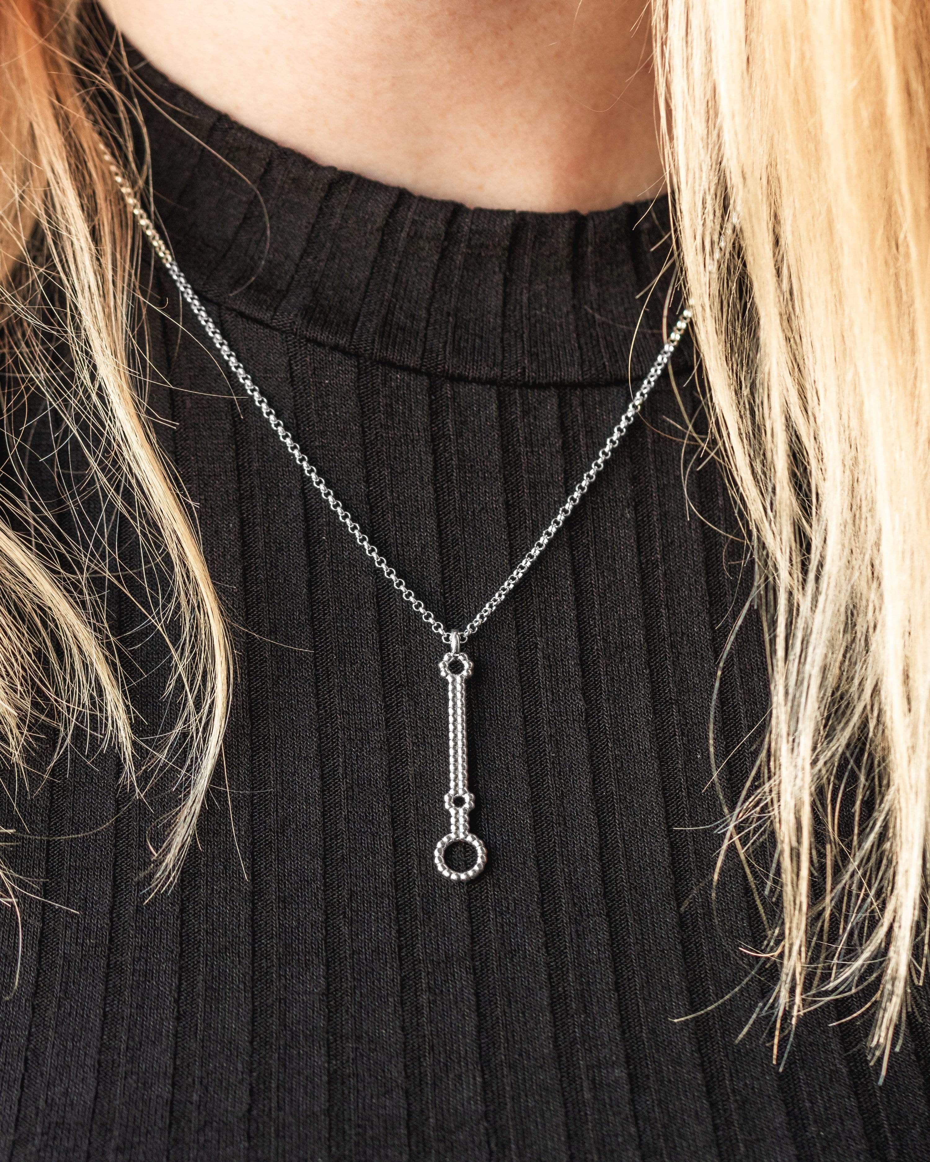 Close-up of microRNA necklace worn by a model, highlighting its elegant scientific design. Close-up of microRNA necklace worn by a model, highlighting its elegant scientific design.