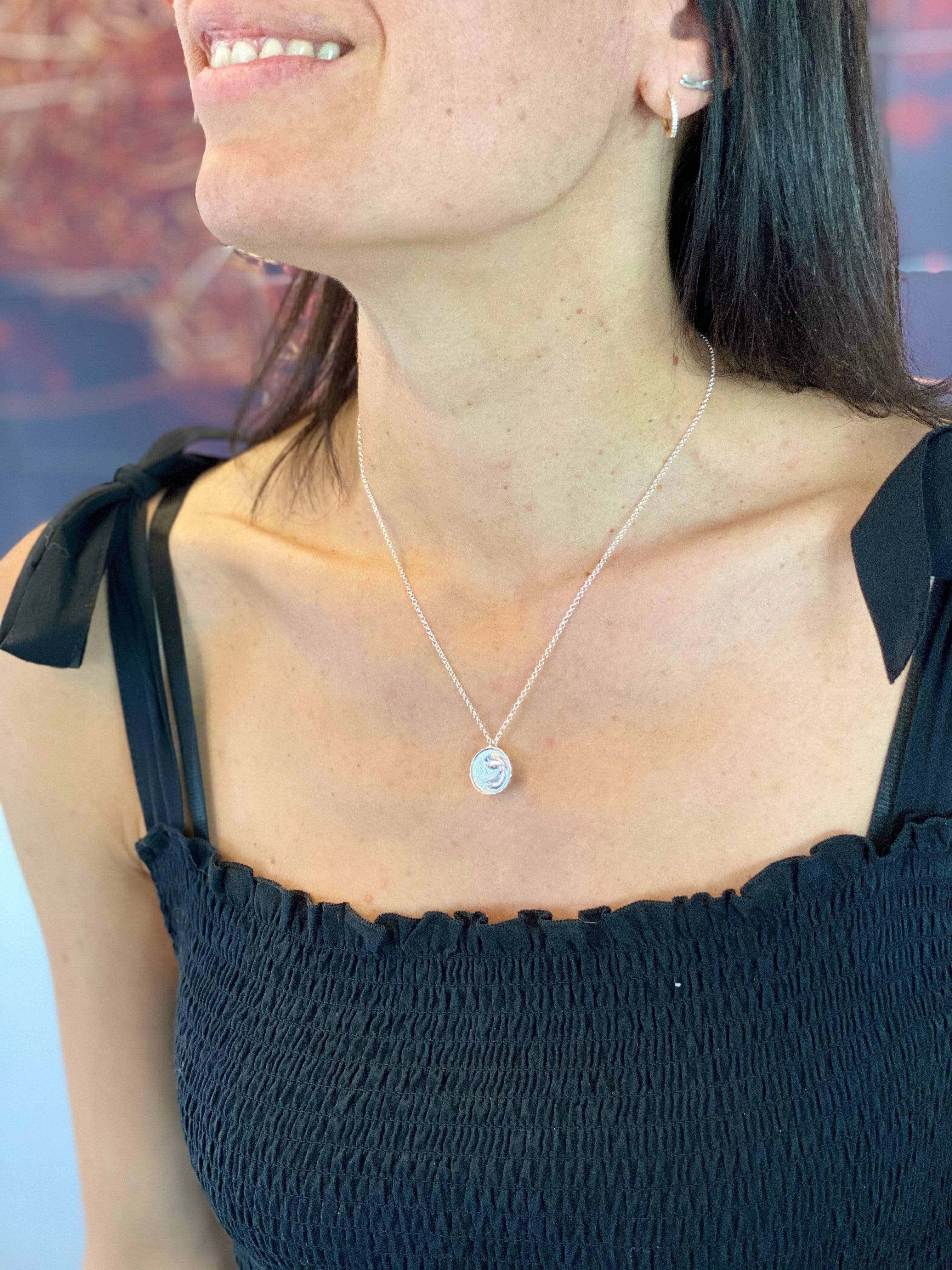 Close-up of monocyte necklace worn by a woman – unique biology-themed accessory. Close-up of monocyte necklace worn by a woman – unique biology-themed accessory.