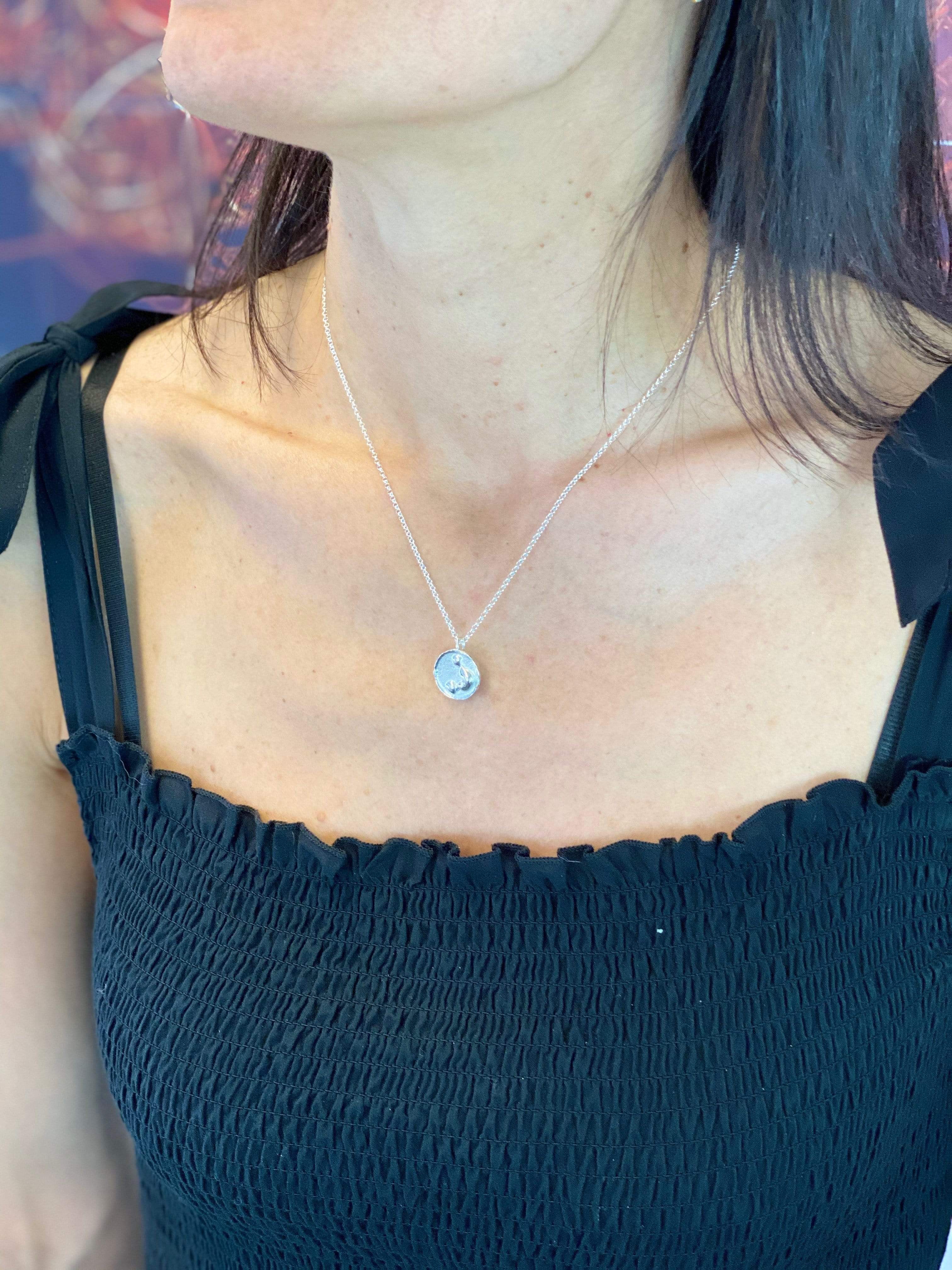 Close-up of a neutrophil necklace on a model, showcasing its elegant design and scientific inspiration. Close-up of a neutrophil necklace on a model, showcasing its elegant design and scientific inspiration.