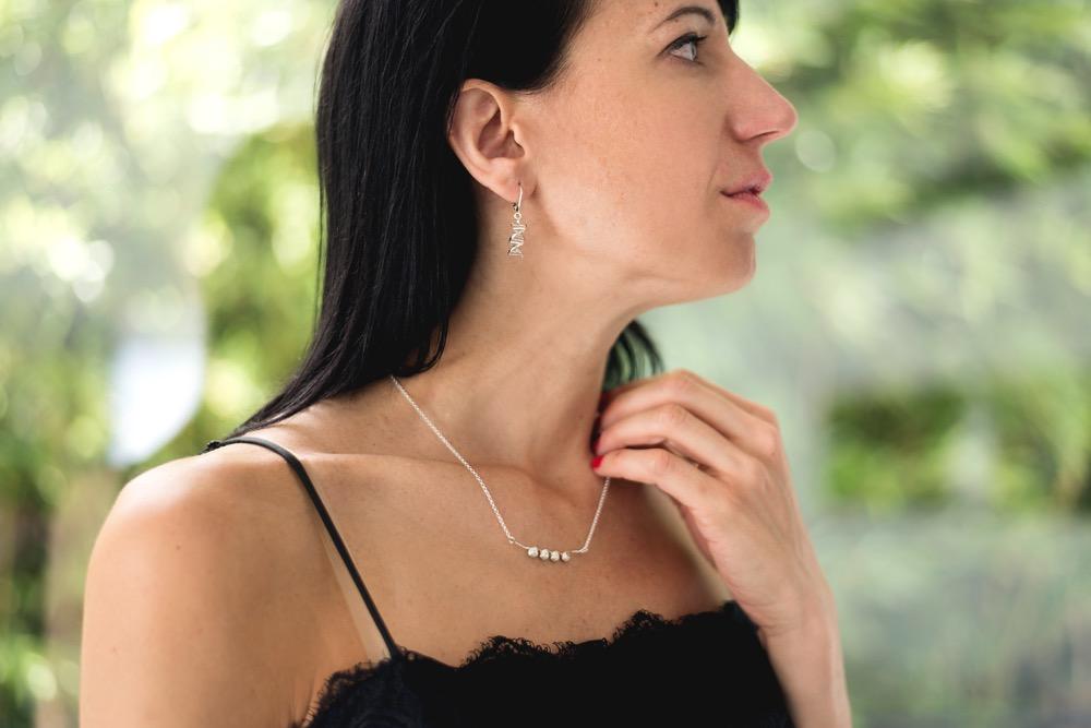 Close-up of the Nucleosomes Necklace worn around the neck, emphasizing its elegant design and scientific inspiration. Close-up of the Nucleosomes Necklace worn around the neck, emphasizing its elegant design and scientific inspiration.