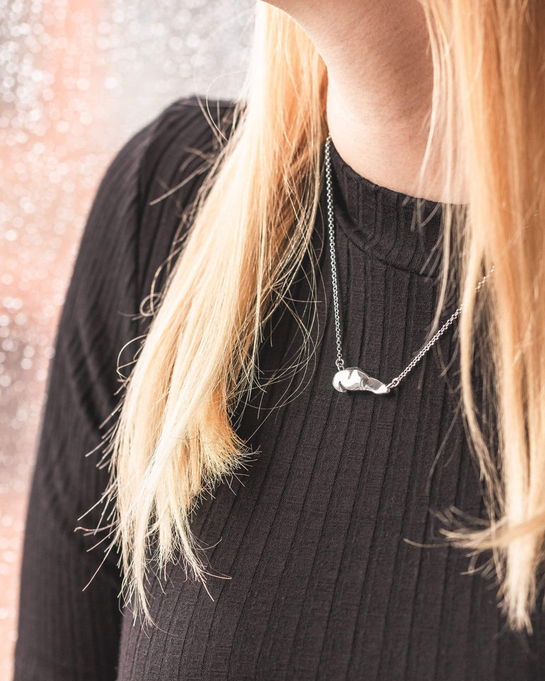 Stylish pancreas necklace worn with a black top – a quirky medical-themed accessory. Stylish pancreas necklace worn with a black top – a quirky medical-themed accessory.