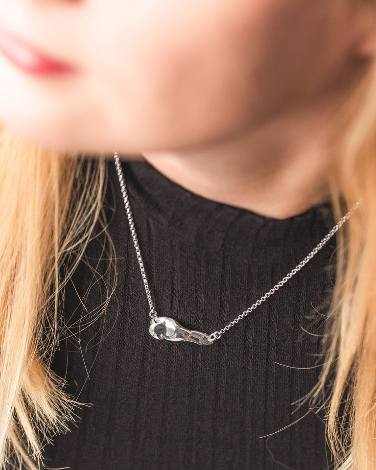 Woman wearing a pancreas necklace, perfect for medical professionals and science enthusiasts. Woman wearing a pancreas necklace, perfect for medical professionals and science enthusiasts.