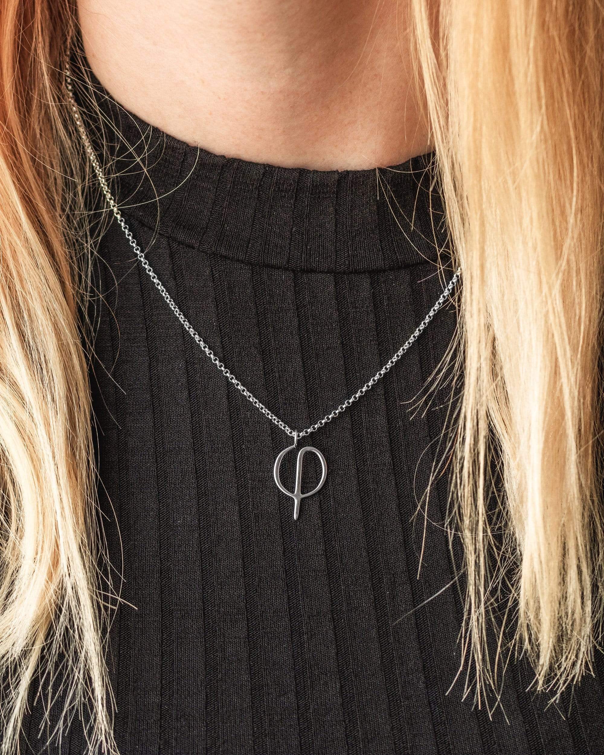 Model wearing the Phi Necklace, showcasing its sleek design and scientific charm in sterling silver. Model wearing the Phi Necklace, showcasing its sleek design and scientific charm in sterling silver.