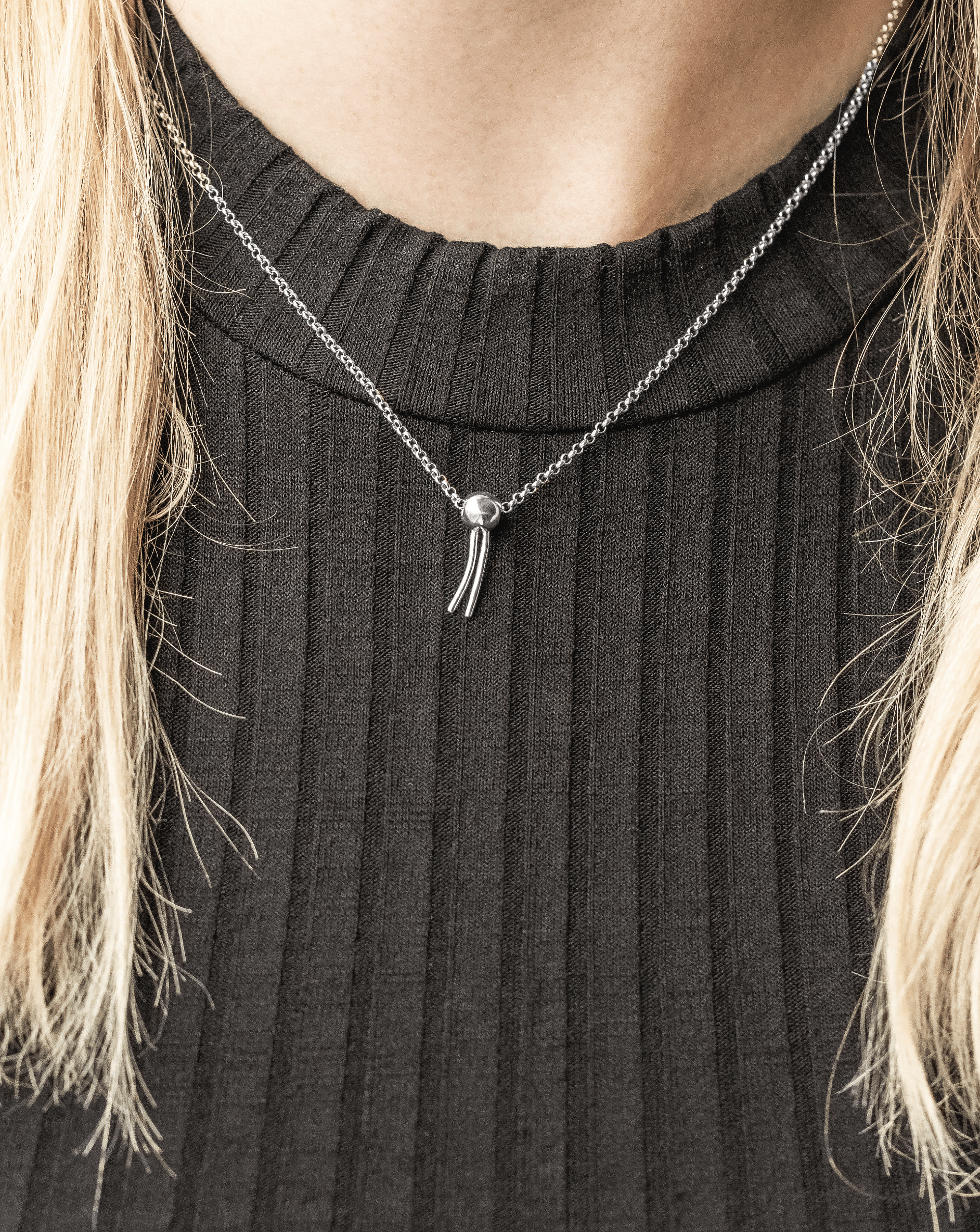 Close-up of phospholipid necklace in silver, showing detailed pendant inspired by amphiphilic molecules. Close-up of phospholipid necklace in silver, showing detailed pendant inspired by amphiphilic molecules.